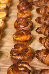 Different kinds of fresh bread on a table. Assortment of fresh bakery products on wooden table.