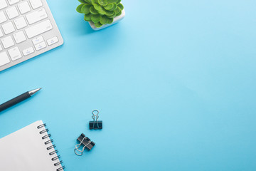 Blue desk office with laptop, smartphone and other work supplies with cup of coffee. Top view with...