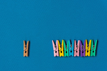 Think differently concept for group of colorful clothespins with another one colorless simple...