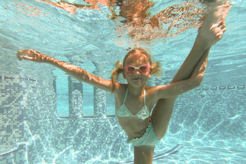 Pretty little girl in swimming pool , summer vacations.
