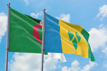 Saint Vincent And The Grenadines and Algeria flags waving in the wind against white cloudy blue sky...