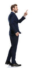 young businessman in navy blue suit pointing finger to side