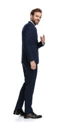 young businessman in navy blue suit pointing finger and smiling