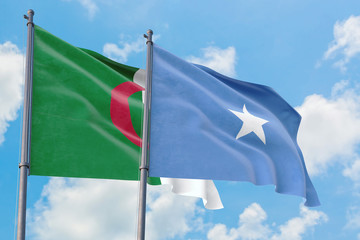Somalia and Algeria flags waving in the wind against white cloudy blue sky together. Diplomacy concept, international relations.