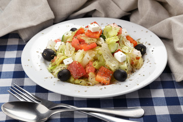 Greek salad with feta cheese, organic olives, juicy tomatoes, red pepper, red onion, cucumber and lettuce. Greek salad with fresh vegetables. Close up view on Salad. Healthy, diet tasty summer dish