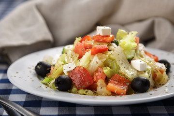Greek salad with feta cheese, organic olives, juicy tomatoes, red pepper, red onion, cucumber and lettuce. Greek salad with fresh vegetables. Close up view on Salad. Healthy, diet tasty summer dish