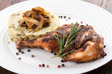 Grilled chicken leg with potatoes, vegetables. Roasted Chicken with Mashed Potatoes and Vegetables served on a white plate.