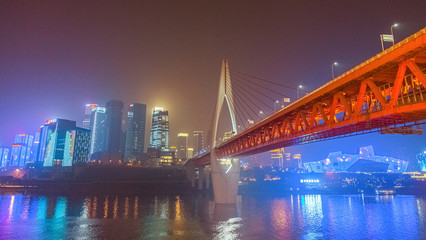Night view of Chongqing city.  View of the bridge over the river.  Lighting and office buildings.  River reflections and lights.  Cityscape