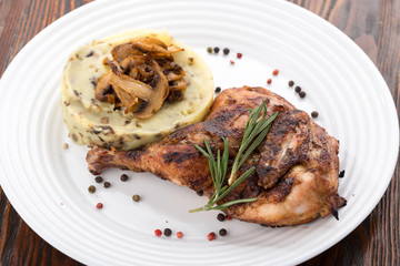Grilled chicken leg with potatoes, vegetables. Roasted Chicken with Mashed Potatoes and Vegetables served on a white plate.