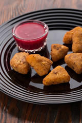nuggets with sauce. Chicken breast nuggets. Plate with tasty nuggets and sauce on wooden table. Close up