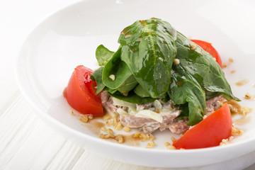 Warm salad with veal, tomatoes, peppers, spinach on white wooden background. Restaurant food. Meat salad with Vegetables. Close up view on Salad with warm baked veal. Space for text
