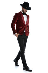 dramatic fashion model in red velvet tuxedo walking