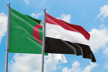 Yemen and Algeria flags waving in the wind against white cloudy blue sky together. Diplomacy concept, international relations.