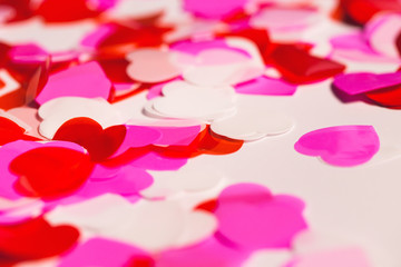 Colorful confetti in a heart shape on white background. Valentine day concept.