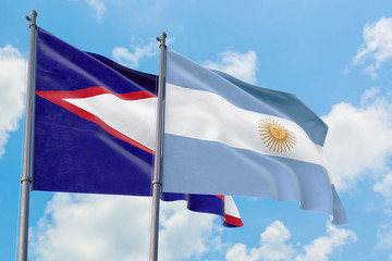 Argentina and American Samoa flags waving in the wind against white cloudy blue sky together....