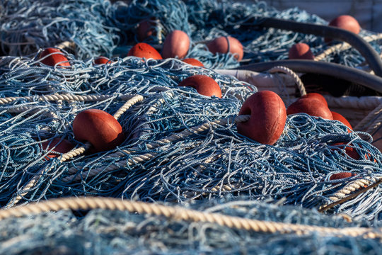 Close up of blue fishing net and floats. Marine background.