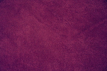 The texture of natural suede. Purple background of leather material.