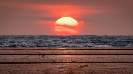 Fototapeta na wymiar Steg mit Sonnenuntergand über dem Meer im Hintergrund