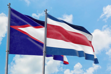 Costa Rica and American Samoa flags waving in the wind against white cloudy blue sky together. Diplomacy concept, international relations.