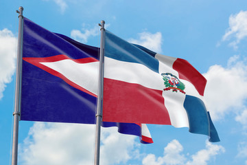 Fototapeta na wymiar Dominican Republic and American Samoa flags waving in the wind against white cloudy blue sky together. Diplomacy concept, international relations.