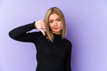 Obraz premium Young blonde caucasian woman isolated showing a dislike gesture, thumbs down. Disagreement concept.