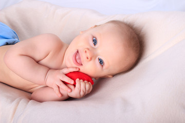 Cute baby with red toy heart. Mother's day card concept