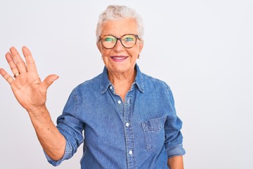 Senior grey-haired woman wearing denim shirt and glasses over isolated white background showing and...