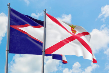 Jersey and American Samoa flags waving in the wind against white cloudy blue sky together. Diplomacy concept, international relations.