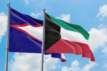 Kuwait and American Samoa flags waving in the wind against white cloudy blue sky together. Diplomacy concept, international relations.