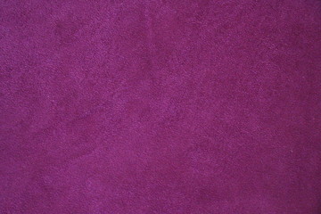 The texture of natural suede. Purple background of leather material.