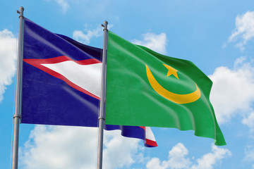 Mauritania and American Samoa flags waving in the wind against white cloudy blue sky together. Diplomacy concept, international relations.
