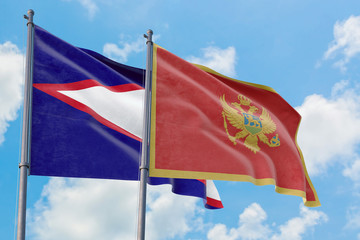 Montenegro and American Samoa flags waving in the wind against white cloudy blue sky together. Diplomacy concept, international relations.