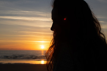 silhouette of a woman on the beach at sunset