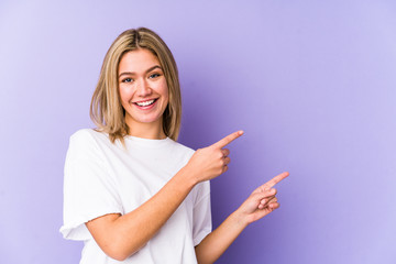 Young blonde caucasian woman isolated excited pointing with forefingers away.