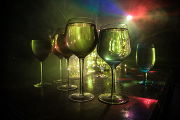 Goblet of white wine on wooden table on wooden wall background