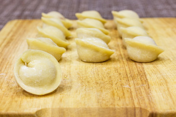 Traditional Russian dumplings hand-made on a cutting Board.