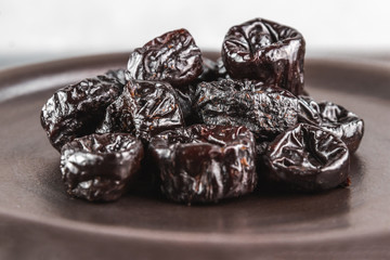 close-up still life background made with black prunes, healthy eating concept, selective focus