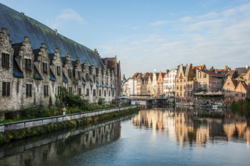 Naklejka premium Wibrujący widok na ulicę w centrum Gandawy, stolicy prowincji Flandria Wschodnia w Belgii, wzdłuż rzeki Leie