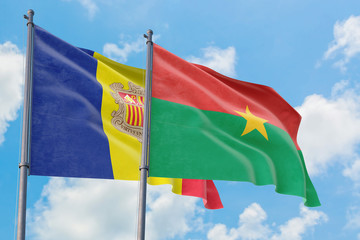 Burkina Faso and Andorra flags waving in the wind against white cloudy blue sky together. Diplomacy concept, international relations.