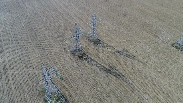 110 kV power transmission towers in an agricultural field, 4k