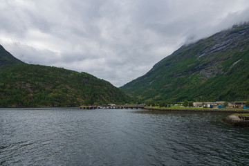Obraz premium Blue water of Geirangerfjord as seen from the town Hellesylt, More og Romsdal, Norway. July 2019
