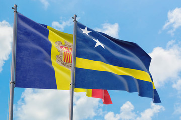 Curacao and Andorra flags waving in the wind against white cloudy blue sky together. Diplomacy concept, international relations.