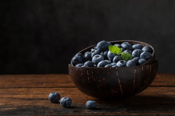 Blueberries and mint leaf in a coconut bowl