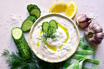 Tzatziki - traditional greek yogurt sauce in a bowl. Top view with copy space.