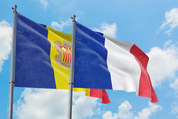 France and Andorra flags waving in the wind against white cloudy blue sky together. Diplomacy concept, international relations.