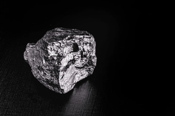big big silver nugget on black background. Raw silver stone, silver nugget native to Liberia, isolated on black background. Mineral extraction.