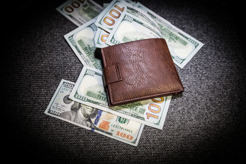 Stylish men's purse with money on wood background.