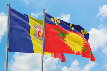 Guadeloupe and Andorra flags waving in the wind against white cloudy blue sky together. Diplomacy concept, international relations.