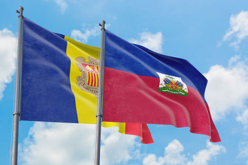 Haiti and Andorra flags waving in the wind against white cloudy blue sky together. Diplomacy concept, international relations.
