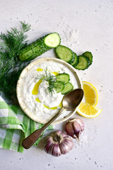 Tzatziki - traditional greek yogurt sauce in a bowl. Top view with copy space.